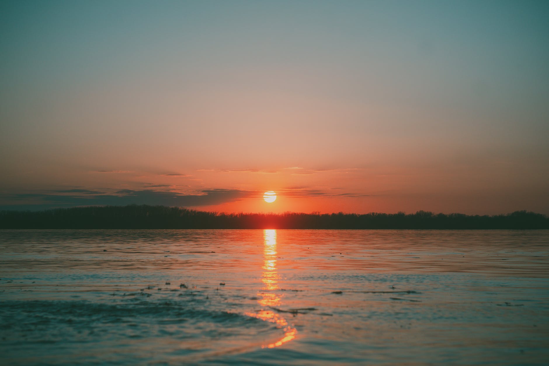 sun setting on horizon at lake in nature