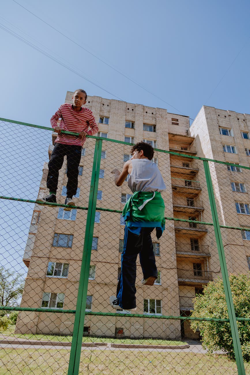 boys climbing a fence